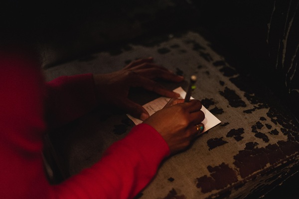 personne qui écrit un mot sur un bout de papier